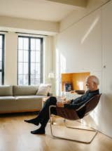 Living, Chair, Sofa, End Tables, Storage, Coffee Tables, Shelves, Lamps, Table, and Light Hardwood Resident Paul Andersson lounges in a Paulistano armchair by Paulo Mendes da Rocha.  Living End Tables Shelves Storage Table Photos from A Pivoting Wall Makes This Tiny Studio Fit For Any Occasion