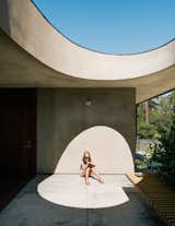 For the breezeway, Schwartz used concrete to achieve the feel of a hardscape courtyard. Uma basks beneath the egg-shaped opening.