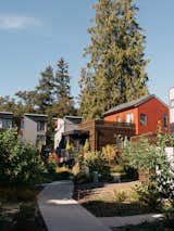 Clad in a mix of stained cedar, Metal Sales corrugated siding, and James Hardie cement board, houses in The Village are arranged along winding paths intended to provide opportunities for neighbors to interact.