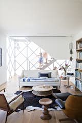 Living Room, Chair, Sofa, Coffee Tables, End Tables, Ceiling Lighting, Pendant Lighting, Medium Hardwood Floor, and Rug Floor Vintage pieces furnish the library, which occupies the ground floor of the modular addition.  Photos from Such Great Heights