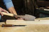 Using a Japanese handsaw, the woodworker, in just one stroke, cuts a channel into the wood, creating a slot for the rice paper.&nbsp;