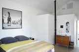 The ceiling is 15 feet high in the bedroom, where a photograph from the set of the movie Giant, which was filmed in Marfa, complements  a chartreuse throw from El Cosmico and a Bruce Lee Supreme skate deck from Exhibitions 2d.