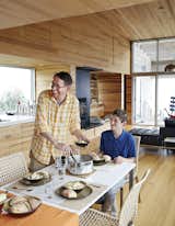 Dining Room, Table, Chair, and Light Hardwood Floor At the IKEA dining table, David Peters and his son, Dashel, enjoy a meal from a Paderno stainless-steel pot made on Prince Edward Island.  Photo 3 of 12 in Sliding House by Dwell from Lights Will Guide You Home