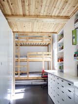 A three-level bunk bed with an additional trundle furnishes the children’s room on the first floor; the cabinetry and drawers are from IKEA.