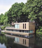 In Hamberg, Germany, Houseboat on the Eilbekkanal is enveloped in sliding timber slats, creating a constant connection between the interior and the exterior.