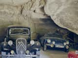 The fleet includes a ruby-red Renault Dauphine and a black Citroën Traction Avant.