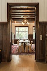 Dining, Table, Chair, Ceiling, Medium Hardwood, Lamps, and Rug Another view of the dining room reveals the original woodwork and character of the 19th-century structure.  Dining Lamps Table Medium Hardwood Ceiling Photos from This New Old House
