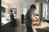 Sarah and her sons prepare a meal in the kitchen, which the Wessels recently upgraded with Bulthaup cabinets, counters, and sink. The stovetop is from Gaggenau and the faucet is from Dornbracht. On the far wall is one of Yoshitomo Nara’s signature eye-patch portraits. 