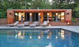 Outdoor, Swimming Pools, Tubs, Shower, Stone Patio, Porch, Deck, and Trees This pool house in Connecticut was fashioned from two shipping containers, bedecked in well-lit cedar, which contrasts beautifully with the blue of the water.  Photo 7 of 10 in 10 Sunny Poolside Prefabs