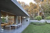 Outdoor, Back Yard, Grass, Concrete Patio, Porch, Deck, Trees, Concrete Fences, Wall, Shrubs, Horizontal Fences, Wall, and Hanging Lighting  Photo 18 of 34 in Tile from House of an Architect