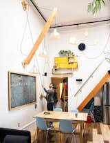 Max devised a movable plywood beam that holds a trio of pendant lamps to swing down as needed.  A wood piece covered in chalkboard paint hides the electrical panel. “Slate was too expensive,” he says.