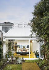 To combat the soul-crushing winter, architect Andrew Maynard re-imagined his Victorian terrace home in Melbourne as a cheerful yellow-hued sanctuary. Equal parts residence (upper level) and convivial studio headquarters (front ground level), it features a 184-square-foot greenhouse addition.