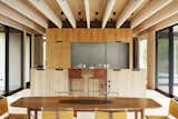 In the kitchen, bar chairs by Mark Albrecht Studio complement the white-oak cabinetry and stainless steel countertops fabricated by  D. Reis Furniture.