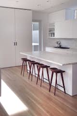 The kitchen is defined by Olympian White Danby marble counters and backsplash by Stone Source. The Tractor stools are by Craig Bassam for BassamFellows.
