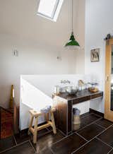 The bathroom occupies the highest chamber of the tower. A vintage pendant purchased from Skinflint Design hangs above a copper sink  by William Holland.