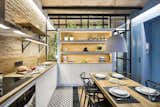 Kitchen, Wood Counter, Wood Backsplashe, Pendant Lighting, Dishwasher, Range, Ceiling Lighting, Drop In Sink, Range Hood, and Ceramic Tile Floor  Photo 1 of 11 in A Smart Layout Maximizes Space in This Compact Urban Beach Apartment in Barcelona