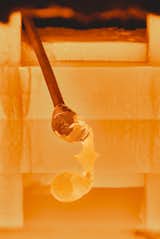 Gathering
A pipe is dipped into the furnace to collect enough molten material for the glass’s base. If the pipe isn’t constantly turned from start to ﬁnish, the glass will gain an uneven shape.  Photo 8 of 17 in Inside Master Glassmaker Simon Pearce’s Sustainable Factory in Vermont