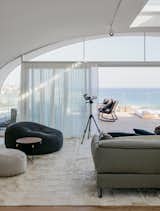 Living Room, Rug Floor, Track Lighting, Chair, Sofa, and Ottomans  Photo 6 of 110 in Take Me Away by Emma Geiszler from A Bondi Beach Penthouse Designed For Barefoot Luxury