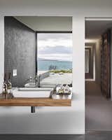 Bath Room, Vessel Sink, and Wood Counter “The house is designed so that you can move around according to the weather and always find somewhere comfortable,

Tasmania, Australia
Dwell Magazine : September / October 2017  Photo 7 of 10 in A Semi-Modular Beach House in Tasmania Floats Over a Site That Survived a Bushfire