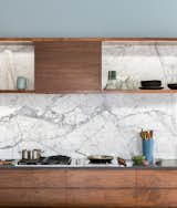 This Denver kitchen sets a marble backsplash, that continues up the wall as the backsplash for a display shelf, against walnut cabinetry and countertops of an alternate gray material. 
