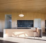Kitchen, Concrete Floor, Pendant Lighting, and Wood Cabinet  Photo 5 of 11 in A Vacation Home in Nova Scotia Takes Cues From the Coastal Landscape