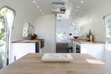 Kitchen, Wood Counter, White Cabinet, Drop In Sink, Cooktops, Dishwasher, and Subway Tile Backsplashe  Photo 8 of 15 in Airstream Dream Team: These Women Travel the Country, Turning Retro RVs Into Homes