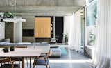 Living Room, Chair, Sofa, Coffee Tables, Table, Pendant Lighting, Accent Lighting, and Concrete Floor  Photo 3 of 11 in Vaulted Skylights and Concrete Columns Connect This Melbourne Home With the Sun