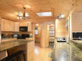 Kitchen, Microwave, Granite Counter, Wood Cabinet, Medium Hardwood Floor, and Ceiling Lighting  Photo 4 of 17 in Enjoy the Rest of Fall by Renting One of These Cozy Cabins or Tree Houses