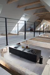 Kitchen, Light Hardwood Floor, Drop In Sink, and Cooktops The mezzanine also holds a library stocked with design titles. Below, a Vipp kitchen offers a refined cooking experience.  Photo 8 of 10 in An Experimental New Hotel Includes a Steel Prefab and a Copenhagen Loft
