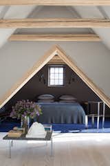 Bedroom, Bed, Wall Lighting, Night Stands, Light Hardwood Floor, and Rug Floor In addition to an ensuite main bedroom, the mezzanine floor sleeps two in a cozy sleeping nook.  Photo 7 of 10 in An Experimental New Hotel Includes a Steel Prefab and a Copenhagen Loft