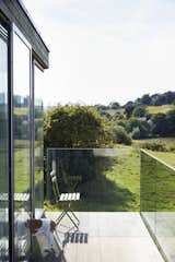 For uninterrupted views, the balcony is wrapped in glass panels.

Pett Level, England
Dwell Magazine : November / December 2017  Photo 8 of 14 in Fall in Love With This British Architect’s Colorful Weekend Retreat