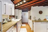 Kitchen, White Cabinet, Wood Counter, Ceiling Lighting, Recessed Lighting, Drop In Sink, and Concrete Backsplashe  Photo 11 of 11 in Live Out Frank Lloyd Wright’s Usonian Vision in This Home That’s Asking $725K
