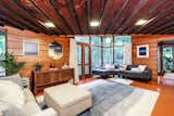 Living Room, Pendant Lighting, Ceiling Lighting, Recessed Lighting, Sofa, Console Tables, Ottomans, Coffee Tables, and Concrete Floor  Photo 9 of 11 in Live Out Frank Lloyd Wright’s Usonian Vision in This Home That’s Asking $725K
