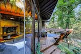 Outdoor, Decking Patio, Porch, Deck, Wood Patio, Porch, Deck, Trees, Wood Fences, Wall, Horizontal Fences, Wall, and Woodland  Photo 3 of 11 in Live Out Frank Lloyd Wright’s Usonian Vision in This Home That’s Asking $725K