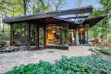 Outdoor, Side Yard, Walkways, Hardscapes, Woodland, Trees, Flowers, Gardens, and Stone Patio, Porch, Deck  Photo 2 of 11 in Live Out Frank Lloyd Wright’s Usonian Vision in This Home That’s Asking $725K