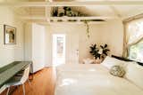 Bedroom, Bed, Chair, Wardrobe, Light Hardwood Floor, Floor Lighting, Lamps, and Night Stands The guest suite, often rented out to visitors and tourists, also incorporates plants and greenery.  Photo 25 of 27 in This 120-Year-Old Home With a Greenhouse Is a Gardener's Paradise