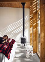 The master suite is warmed by a Badger 3112 woodstove by Morsø.