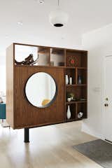 To break up the long living room, Pettit created a walnut bookcase at the entrance.