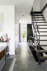 Hallway and Slate Floor Bryan painted the metal band that runs around the top of each staircase Space Black by Benjamin Moore to match the treads.  Photo 1 of 65 in Stairs by Vertex Design from A New York Transplant Remakes One of Mies van der Rohe’s Coveted Townhouses in Detroit