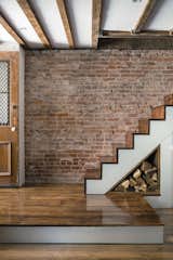 When Tom Givone bought a partially finished, abandoned house in Manhattan’s Washington Heights neighborhood in 1998, the building "was like a shell that looked like an active job site—paint had hardened over and mud was on the walls," the owner recalls. The self-taught designer restored a number of floorboards and stair treads in the home using salvaged wood from a farmhouse upstate. Fittingly, he incorporated a small nook for firewood underneath the stairs.