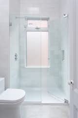 Polished concrete floors and oversized quartz marble subway tiles outfit the second floor bathroom.
