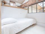 Bedroom, Shelves, Bed, and Light Hardwood Floor  Photo 11 of 14 in Canal Saint-Martin Loft by Dwell