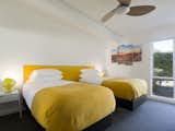 Bedroom, Night Stands, Table Lighting, Carpet Floor, Ceiling Lighting, and Bed  Photo 5 of 9 in Racquet Club North House With a Citrus-Colored Door by Dwell