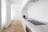 Kitchen, Wall Oven, Cooktops, Light Hardwood Floor, Undermount Sink, Marble Counter, and White Cabinet  Photo 4 of 8 in Quai d'Orléans by Dwell