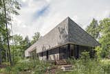 Vince and Adrienne Murphy’s rural retreat is clad in gray shingles and gray-stained pine. “They wanted the cottage to meld into the woods and be visually quiet,” says architect Kelly Doran, who worked with Portico Timber Frames to build the 2,500-square-foot home.