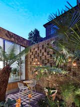 The exterior courtyard's tile floor mimics the tile treatment at the entry for cohesion, and the perforated brickwork creates a lovely pattern when backlit at night.