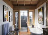 Bath Room, Medium Hardwood Floor, Freestanding Tub, Rug Floor, and One Piece Toilet  Photos from This Eclectic Beach Bungalow on Fire Island Was Saved After Sandy