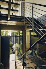 Staircase, Wood Tread, Wood Railing, and Metal Railing Near the front door, charred oak treads float on a blackened steel stringer to the master suite and on to the roof.  Photo 7 of 21 in Here Are the Modern Prefab Designs That Amazon’s Investing In from Step Inside Will Arnett’s Prefab-Hybrid Home