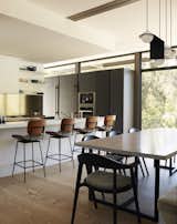 Dining Room, Stools, Bar, Chair, Light Hardwood Floor, Pendant Lighting, and Table The appliances are by Miele and the Cojo stools are by Thomas Hayes.  Photos from Step Inside Will Arnett’s Prefab-Hybrid Home