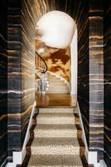 Inspired by the glinting waters of the San Francisco Bay, a shimmering entrance by Molie Malone greets you as you enter the Marina home. Light bounces off the gold tones in the silk-lined walls with the intention to "invite you not just to come inside the front door, but to come in and fully explore."